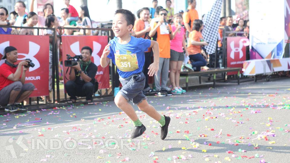 Seorang anak tampak berlari dengan rasa senang di acara Serpong Green Warrior Run 2016.